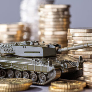 Tank between stacks of coins as a symbol of high armament expenditure