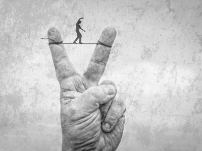 Hand mit V-Zeichen, mensch balanciert zwischen 2 Finger auf dem einem Seil